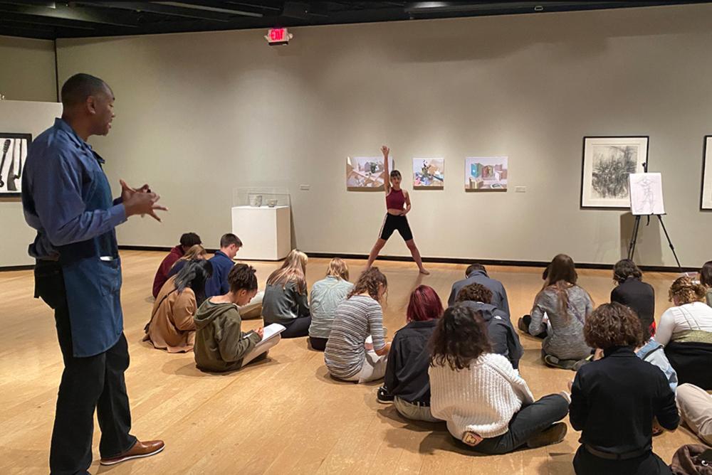 Students draw a model in an art class.