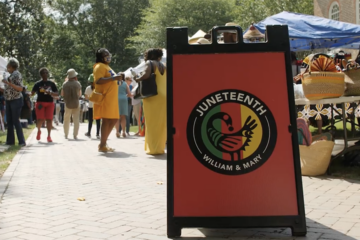 Sign that reads "Juneteenth" with crowd behind it