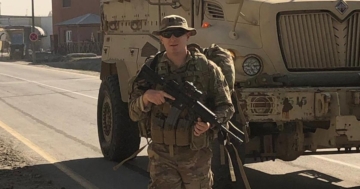 Man in front of tank holding gun