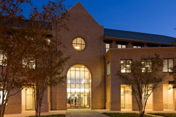 Lights shine in a large brick building at night