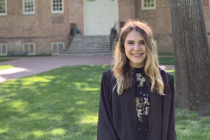 Kristen Popham stands by a tree in an outdoor location