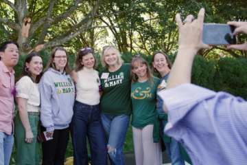 A group of people smile while posting for a photo together.