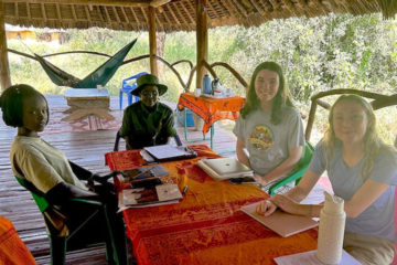 People sit at a table in an outdoor location.