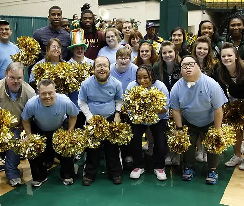 clients-holding-pom-poms-and-posing-with-cheerleaders.webp