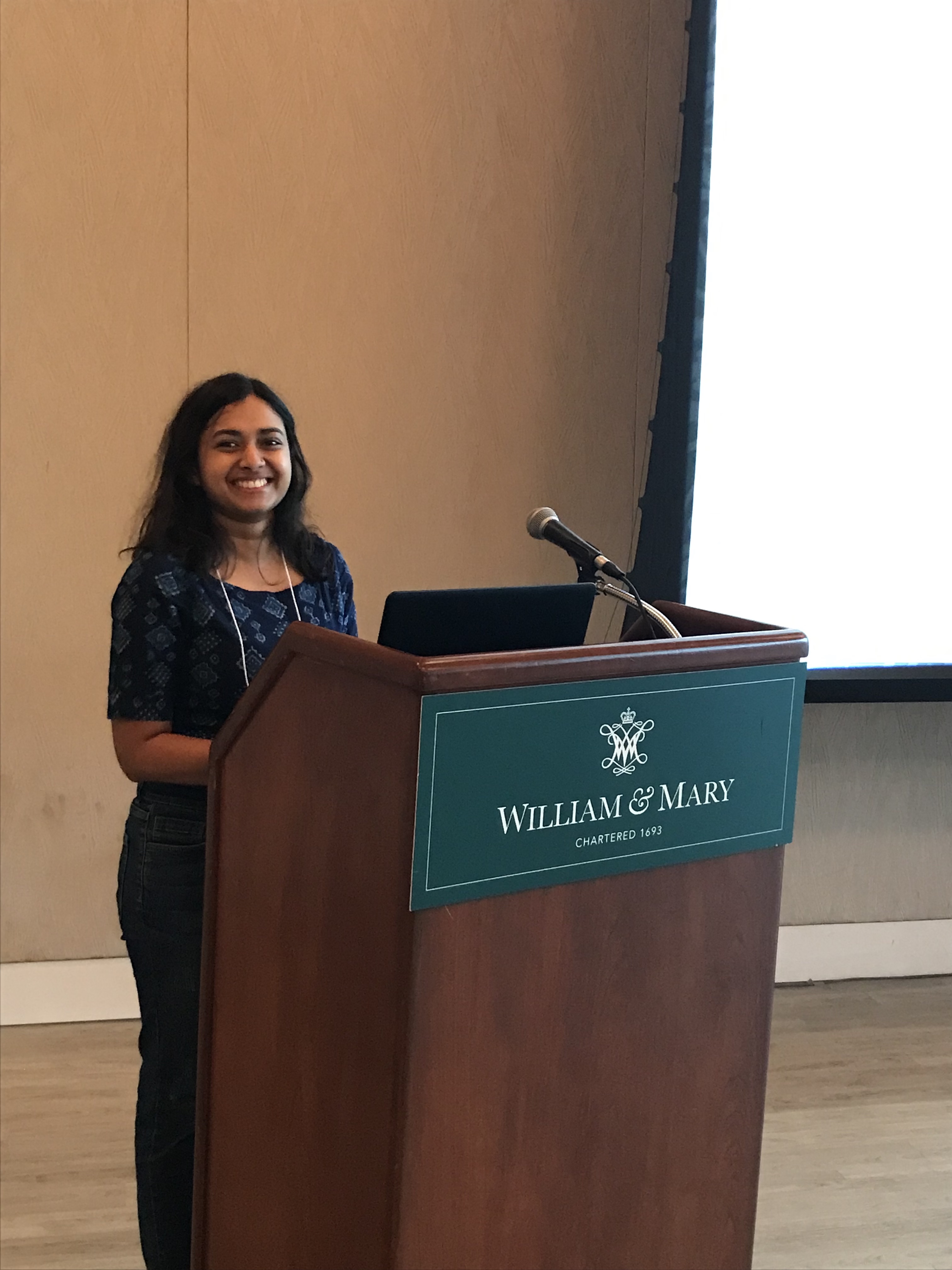Anu presenting at the podium 
