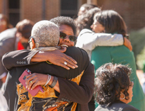 Friends embrace at the ceremony. (Photo by Skip Rowland '83)