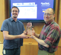 Derek Drummond of Dominion Enterprises (left) presents the HackU Best in Show trophy to Michael Lewis, chair of William & 玛丽’s Department of Computer Science. The trophy recognizes FloorRent, an app created by a group of William & 玛丽 students. (Photo by Joseph McClain)