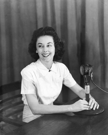 On the same wavelength: Still wearing her Red Cross uniform, Virginia Allen ’40 broadcasts to the China, Burma and India Theatre as G.I. Jill, 1945.