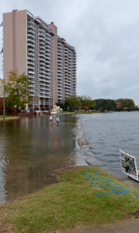 Two girls wade through flood waters near the Hague in Norfolk during the height of the king tide. (VIMS photo)