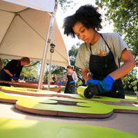 An art student rolls ink onto a woodcut panel. (Photo by Stephen Salpukas)