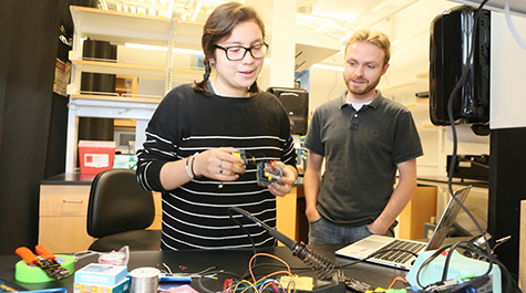 Kelly Rodriguez-Vasquez demonstrates the AIRduino device in the lab with Nathan Kidwell