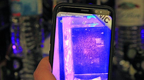A cellphone camera held in front of an atomic imaging station shows a scattering of atoms inside William & 玛丽’s Ultracold AMO Physics Laboratory. 