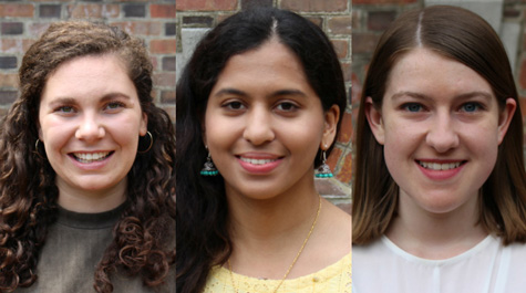 Three students standing in front of a brick wall