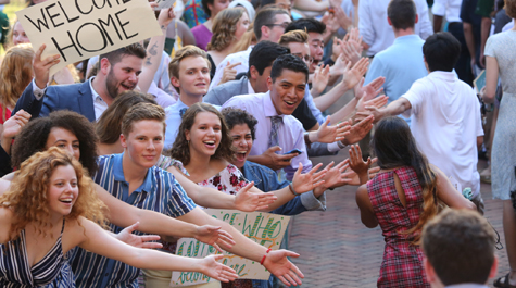 Students offer their hands in greeting to new students