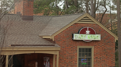 A brick building with a sign saying The Daily Grind