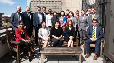 Members of the board pose for a photo together on a sunny patio
