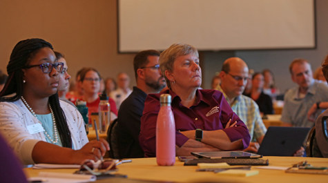 People sitting at tables listening to a speaker