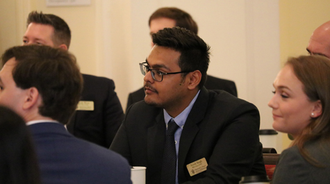 Students in suits sit at tables