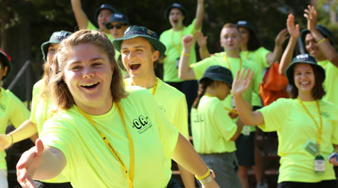 An orientation aide reaches out a hand as others behind her cheer