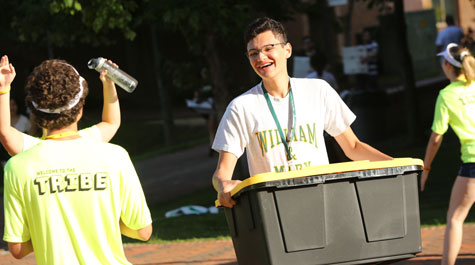 A new student carries belongings to his dorm