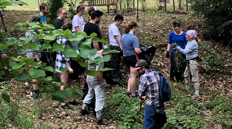 ordan Martin and Martha Case stand in the woods around the Crim Dell and talk to a crew of volunteers.