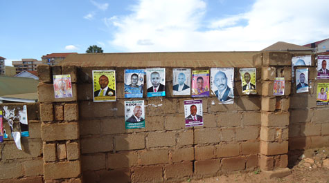 Brick wall papered with Uganda election posters