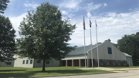 The exterior of the Virginia Peninsula Regional Jail with a tree nearby and blue skies overhead
