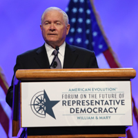 Robert Gates stands behind a podium
