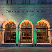 Green uplighting illuminates the entrance of the Chrysler Museum at night