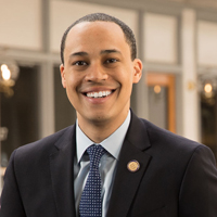 Jay Jones wearing a suit and smiling at the camera