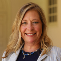 Pamela Mason stands on the Wren Building's portico and smiles