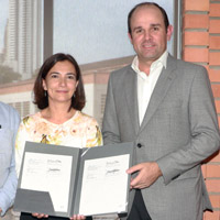 Two people hold up a memorandum of understanding