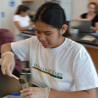 A student spoons soil samples taken around campus 