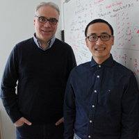 Enrico Rossi and Xiang Hu stand in front of a whiteboard
