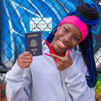 A student holds and points to a U.S. passport