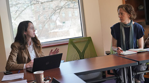 Elizabeth Harbron and Shelly Laurenzo seated at a table, talk to each other