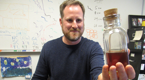 William & 玛丽 geologist Jim Kaste examines a jar of honey