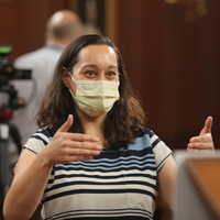 Lisa Crawford wears a mask and gestures with her hands