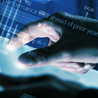 A hand on a keyboard with data on screen