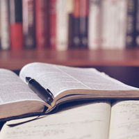 Notebooks open in front of bookshelf