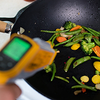 An instrument takes reading from a pan of stir fry