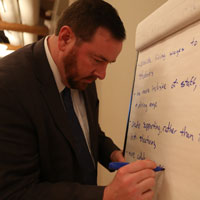 Jeremy Martin writes data points down on a large white board