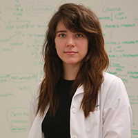 Portrait photograph of Eden Maness in the lab wearing a lab coat