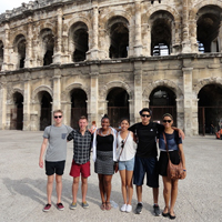 People stand in front of the colosseum in Rome