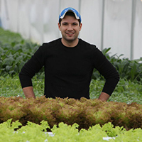 Thomas Vandiver stands in a greenhouse 
