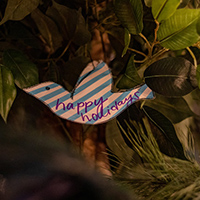 A close up of the Yule log with a dove-shaped card that reads "happy holidays"