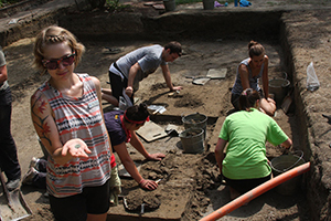 Crystal Castleberry, an intern on the 2013 dig, displays an 18th-century coin bearing the visage of George III. William & 玛丽 photo (from 2013) by Joseph McClain