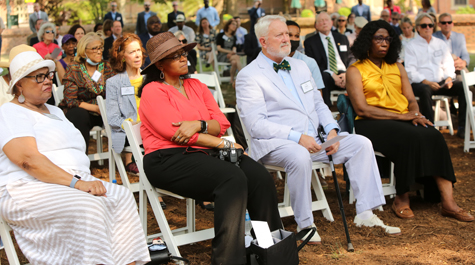 People sit in a chairs at an outdoor event