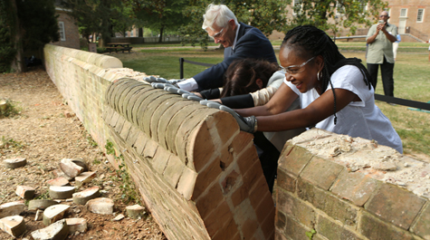 Taylor Reveley, Katherine Rowe and Jody Allen push over a section of wall
