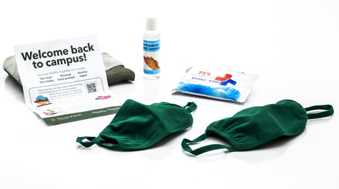 Masks, hand sanitizer, hand wipes and a piece of paper that says welcome back to campus